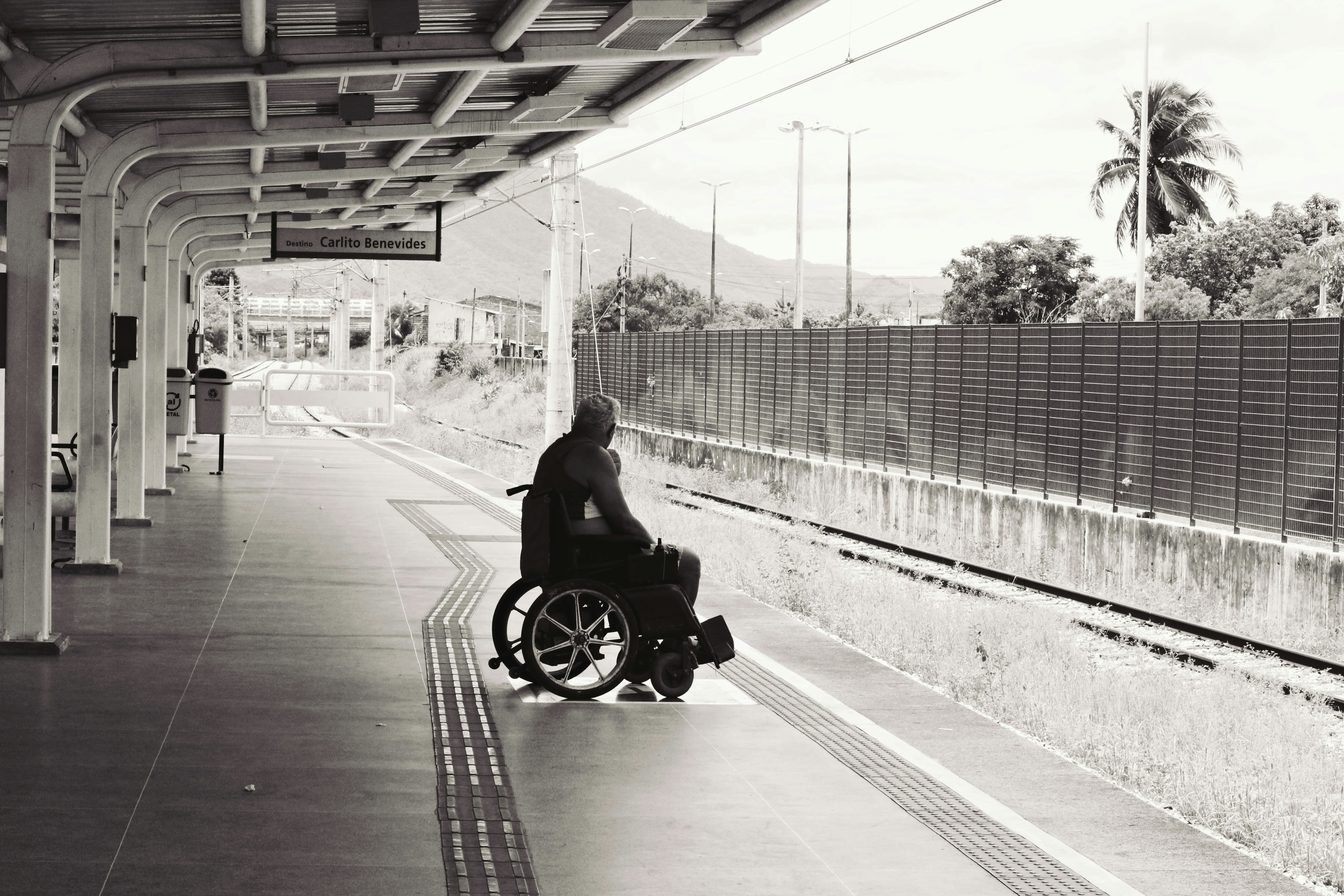 Person in wheelchair at a train station demonstrating community independence